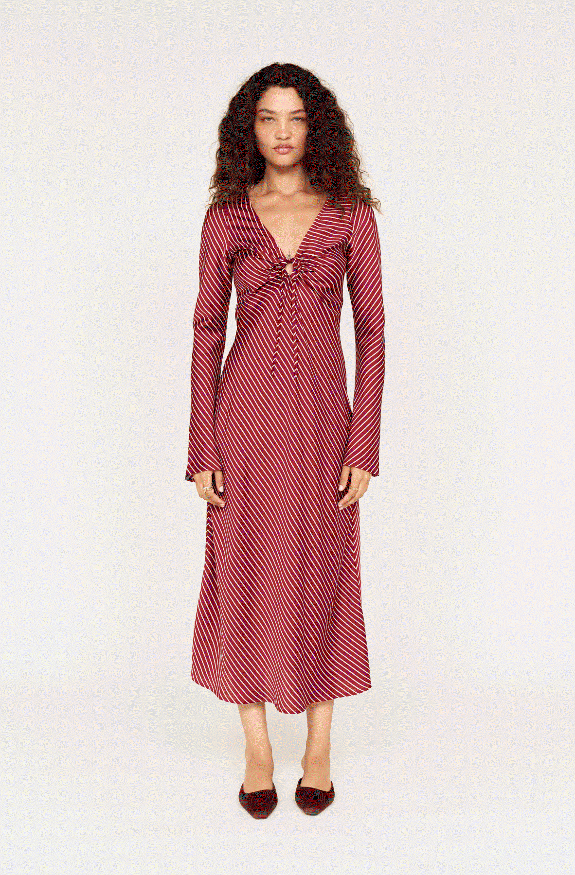 model wears various looks in burgundy based white pinstripe fabric. 