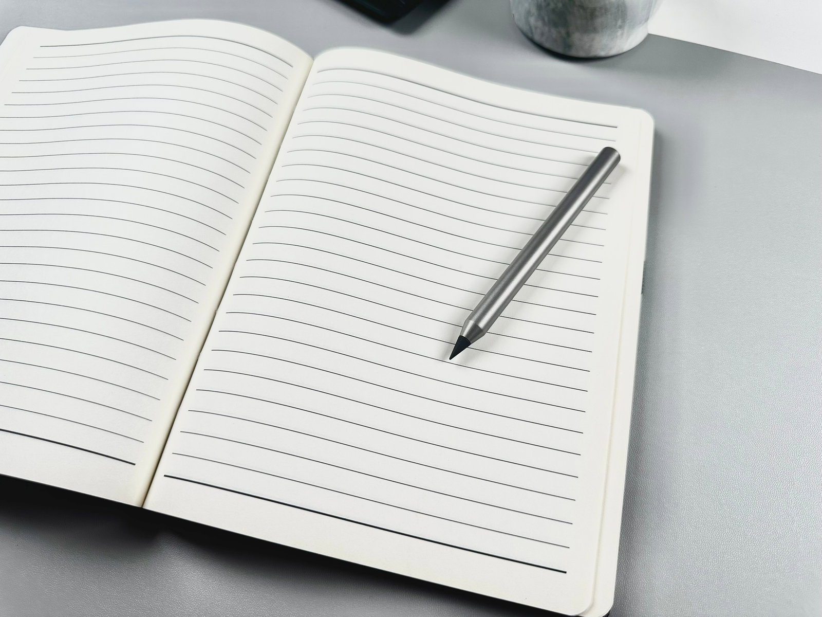 Infinity Pencil on open notebook