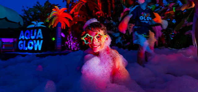 A young boy playing with bubbles during AquaGlow at Adventure Island