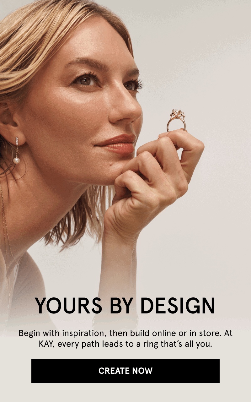 Close-up of female model wearing pearl drop earrings and holding diamond engagement ring. Yours by design. Click create now.