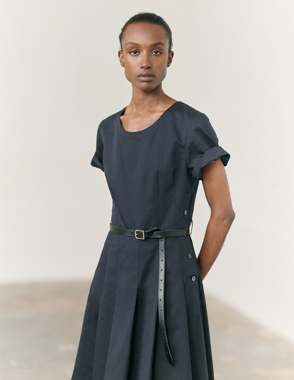 Dress with soft pleating and narrow belt