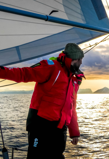 Man looking into the horizon with red sailing jacket