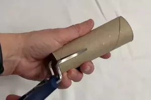 She slides a cut paper towel tube onto a plastic hanger for this 5-minute hack