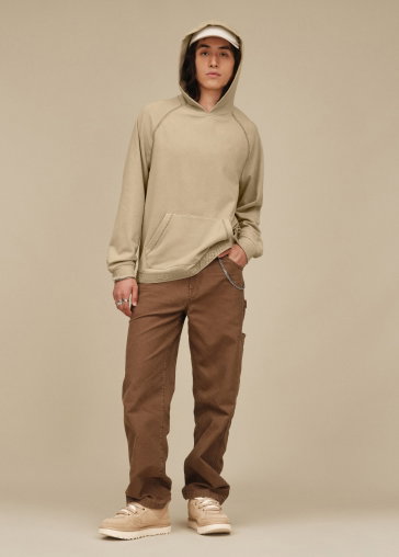 A studio shot of a model in a leopard print hat and trousers, a crew-neck jumper and the Seaside Ii Flip Flops