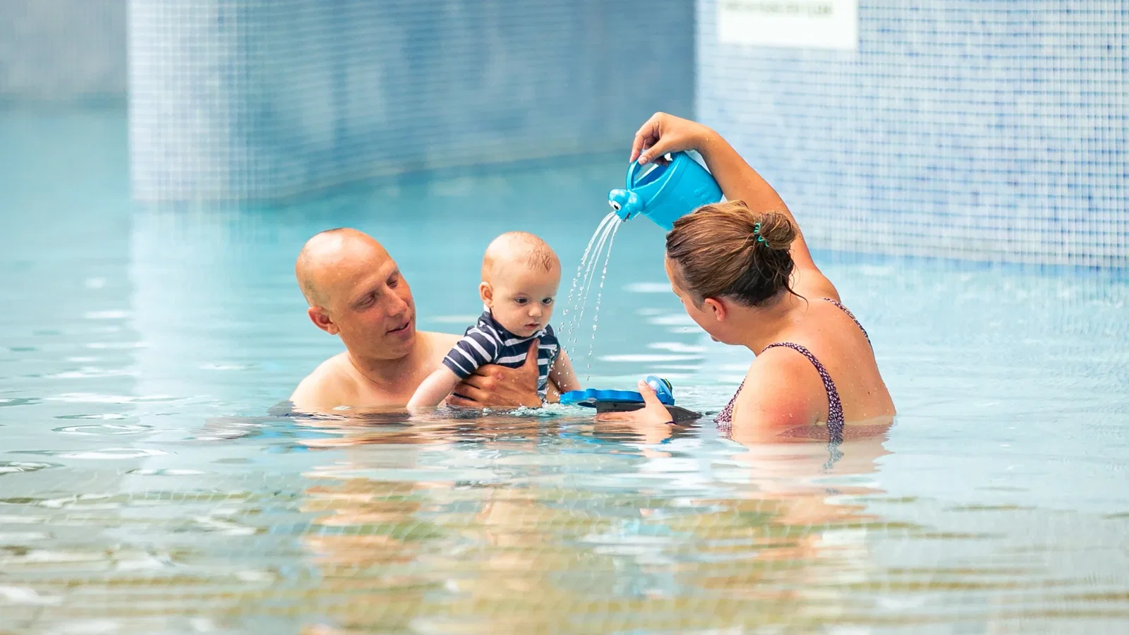 Mum and dad playing with baby at the blue lagoon