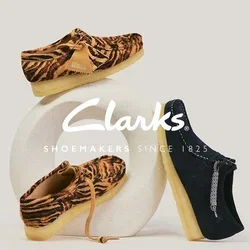 Deux mocassins à imprimé tigre marron et un mocassin bleu marine avec une semelle beige, présentés sur un support sculptural blanc.