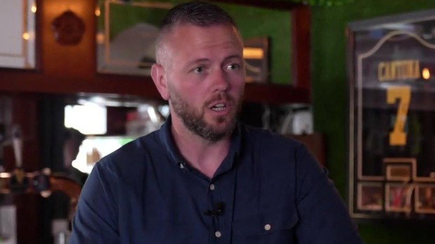 Robert Kenyon speaking to the BBC in a pub in the Makerfield seat. He is wearing a dark blue shirt with a microphone clipped to his collar.