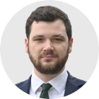 Henry Zeffman has short dark hair and a beard. He wears a suit jacket, white shirt and tie.