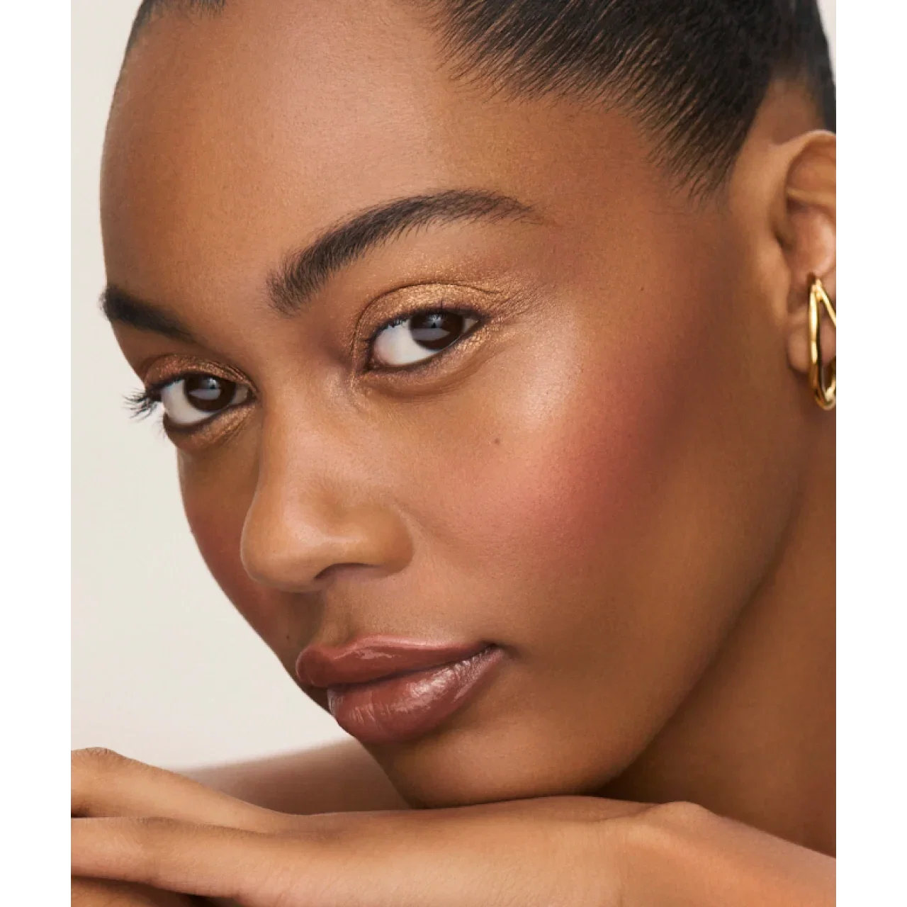 Close-up of a woman's face wearing sun-warmed tones makeup.