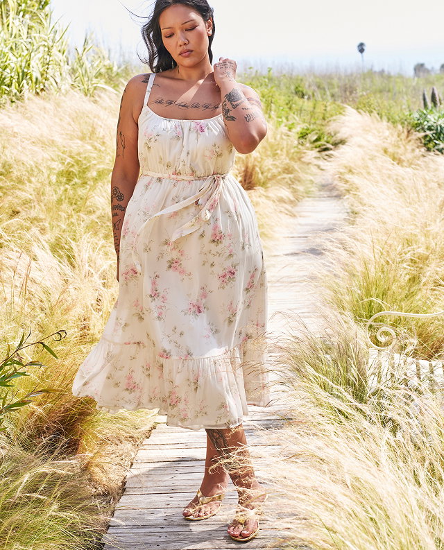 Woman in a floral dress on a beach boardwalk