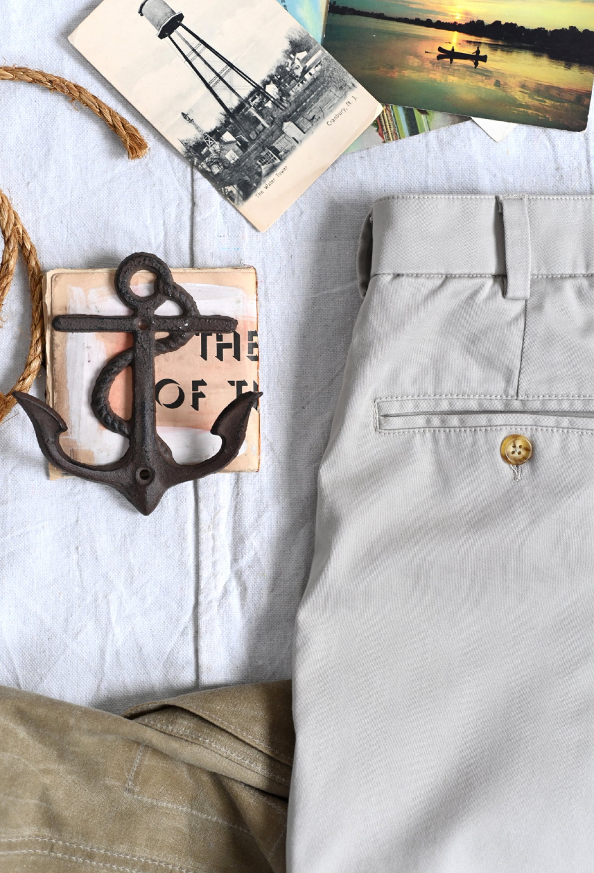 A close up of the back pocket and belt seam work of a pair of Bills Khakis pants with certain martitime and travel objects at the photo crop