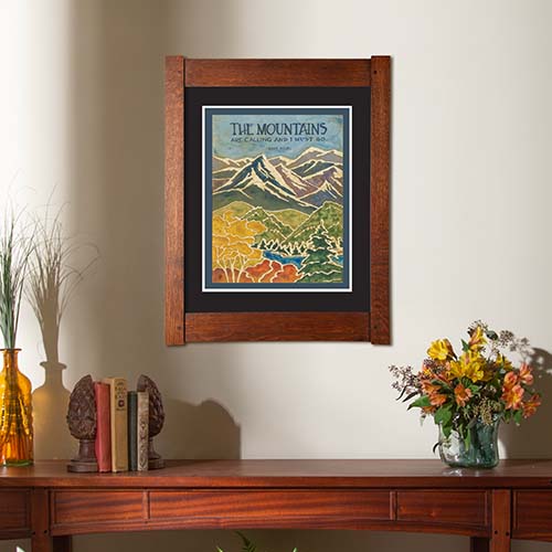 A painted mountain landscape scene hangs on the wall above a decorated side table.