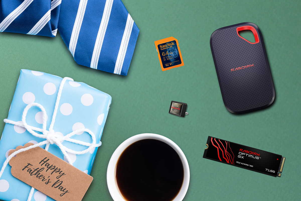 A Father's Day flat lay with a blue polka dot gift, a striped tie, a cup of coffee, and various SanDisk storage devices.