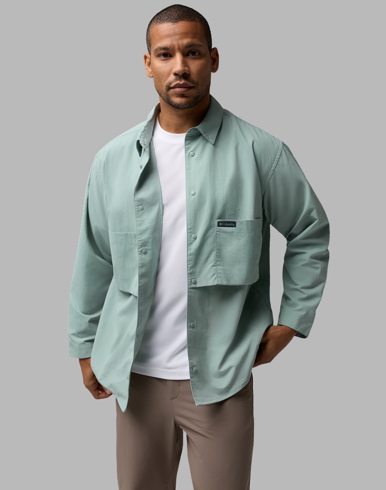 A man wearing a white shirt with a blue button-up shirt over it.