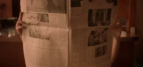 A woman opening up a newsletter.