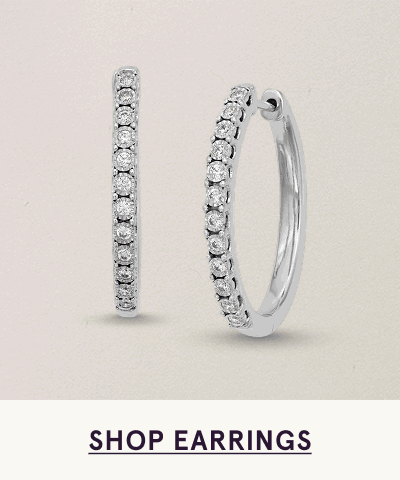 Pair of classic silver hoops lined with single row of round-cut diamonds along the front. Click here to shop earrings