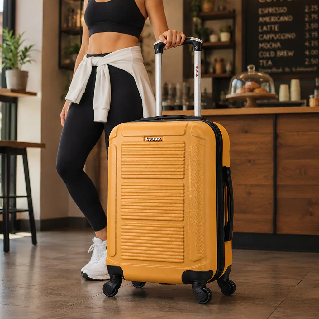 Woman in athletic wear posing with yellow hard-shell InUSA carry-on luggage in modern café setting