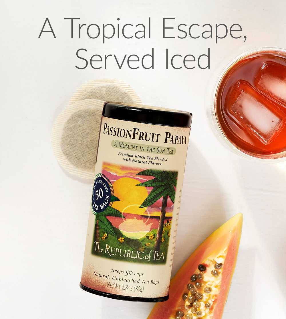 Tin of PassionFruit Papaya tea with a piece of papaya fruit and teacup next to tin