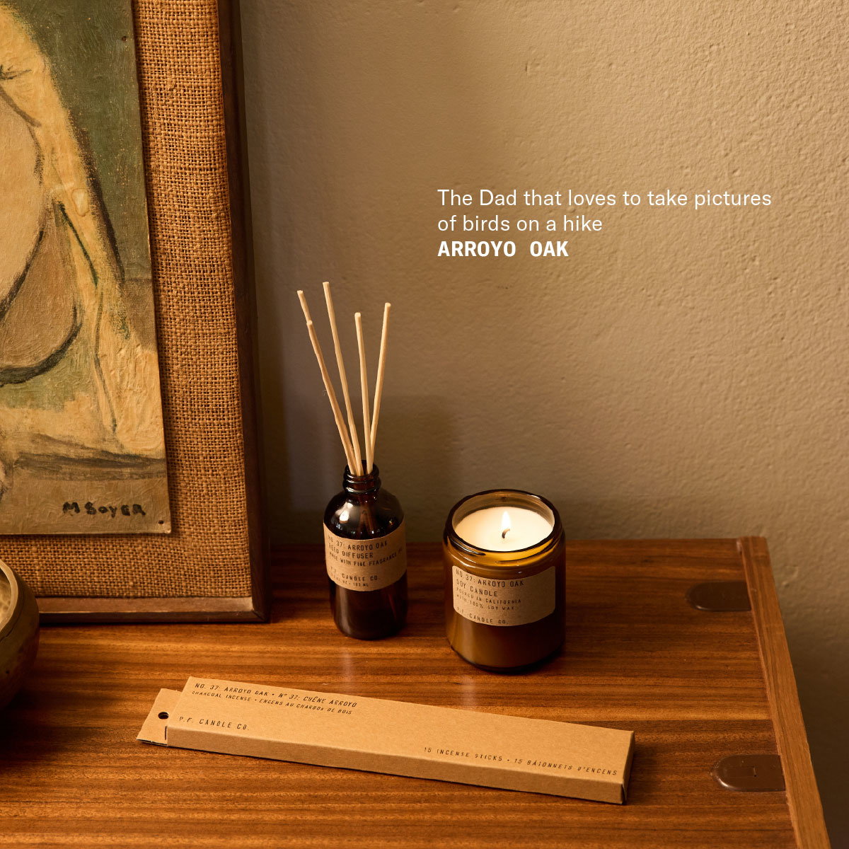 The Dad that loves to take pictures of birds on a hike Arroyo Oak [reed diffuser, candle, and incense sticks packaging on counter]