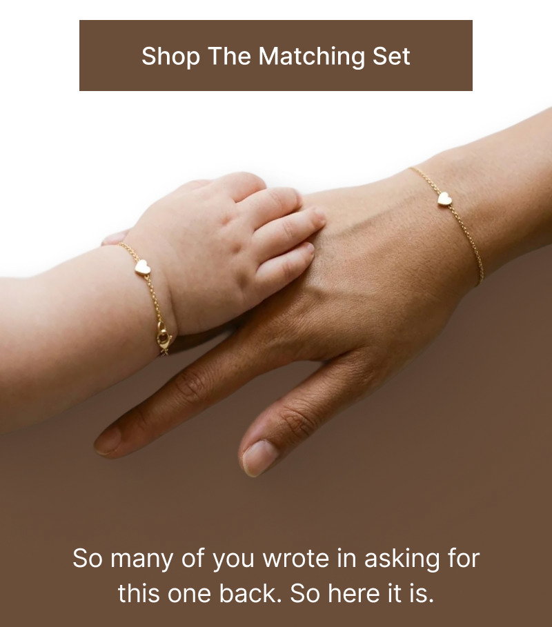 Brown button reading Shop The Matching Set above an image of an adult hand and baby hand wearing matching heart bracelets.