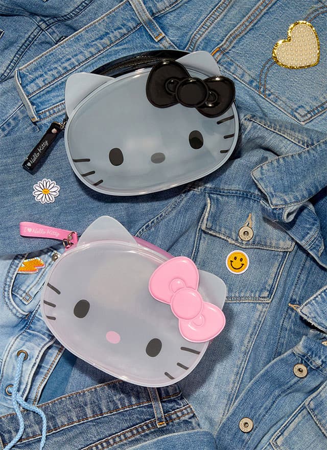 Two Hello Kitty zipper pouches on a background of denim jackets laid flat