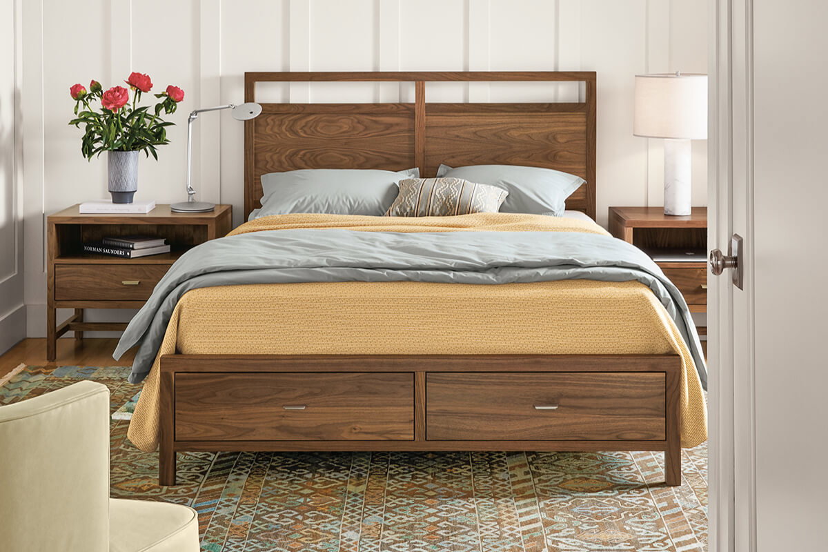 Berkeley bed with walnut finish, storage drawers, grey and mustard bedding, and matching nightstands.