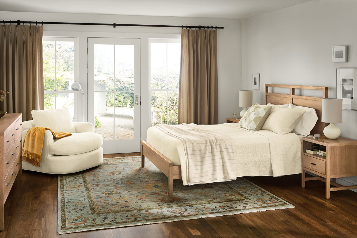 Berkeley bedroom featuring wood bed frame, nightstands and dresser with cream textiles and natural light.