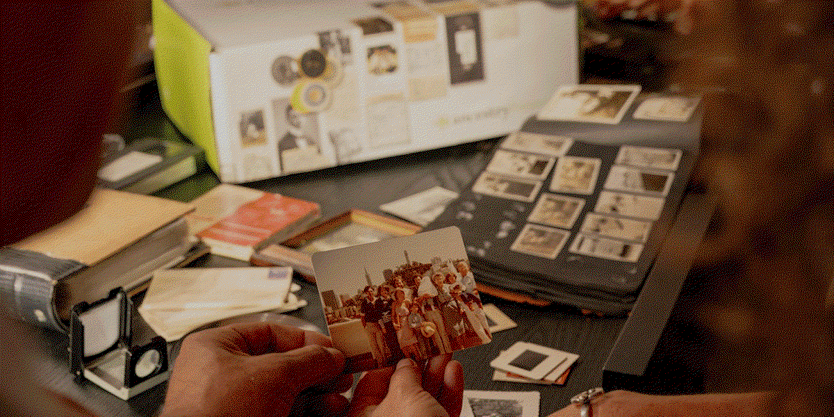 A gif alternating across three images with overlaid text: a box with filled with slides, vhs, and film reels with the text “You pack,” technicians converting those records to a digital format with the text “We digitize,” and two people looking at a the media on a tv with the text, “Share together.”