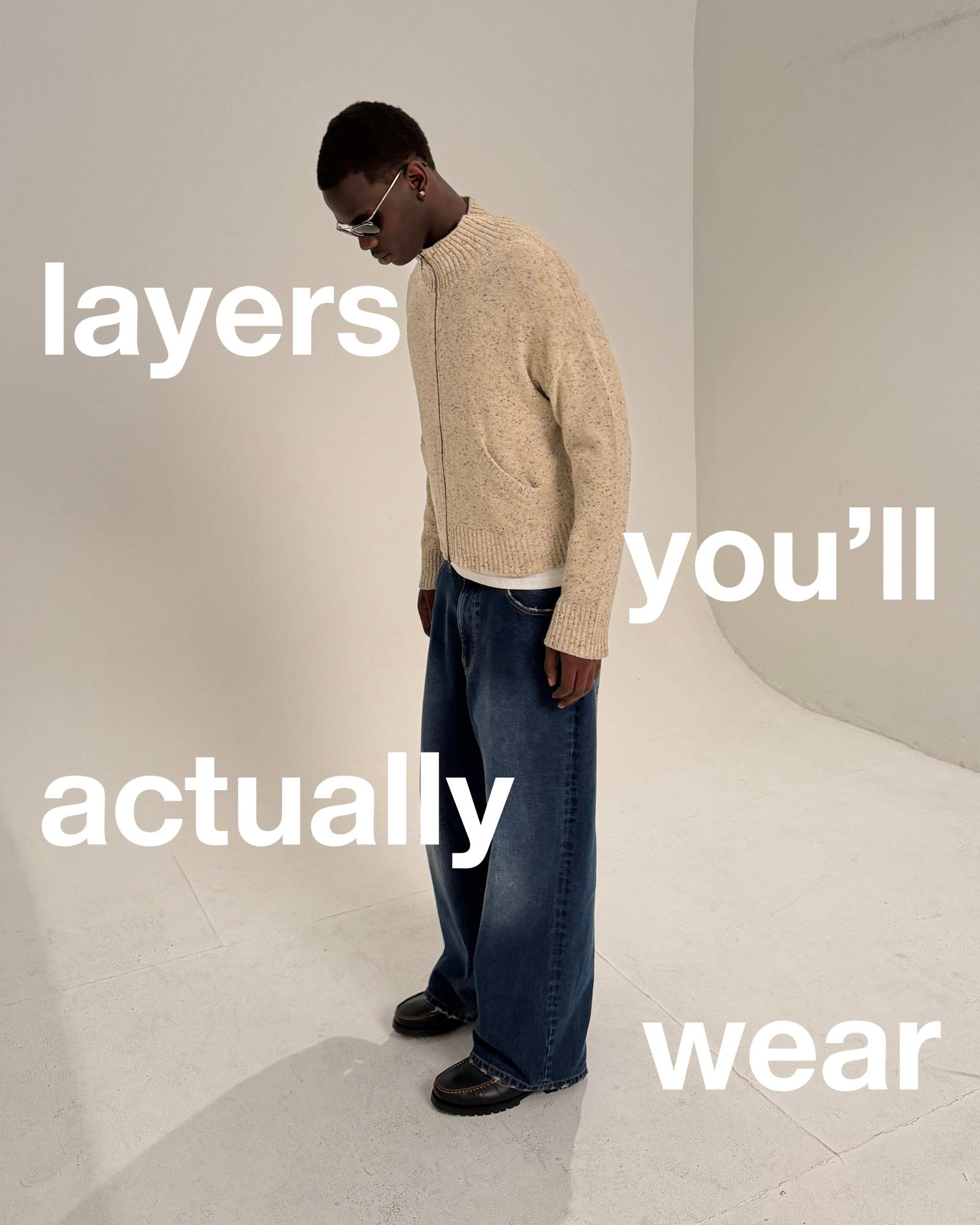 A medium shot shows a person wearing a speckled beige zip-up sweater over a white t-shirt and dark wash wide-leg jeans, with the words 'layers you'll ...