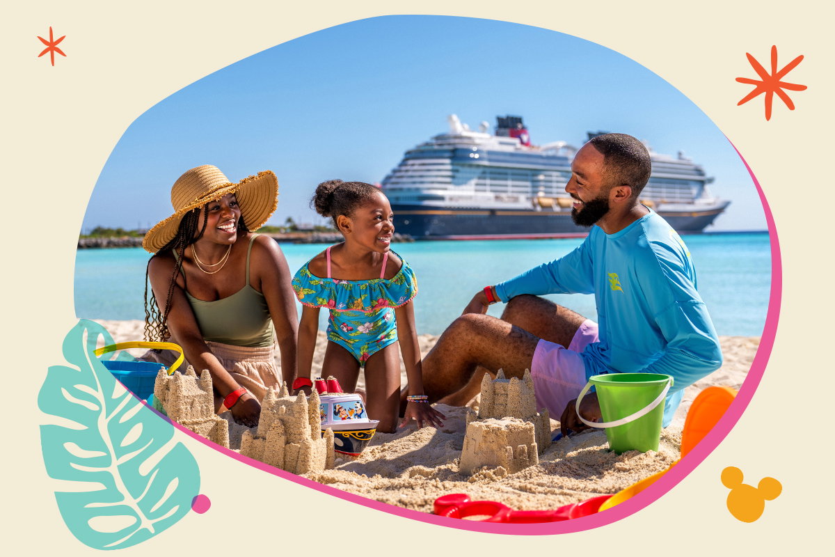 A family builds sand castles on the beach with the Disney cruise ship docked in the distance.