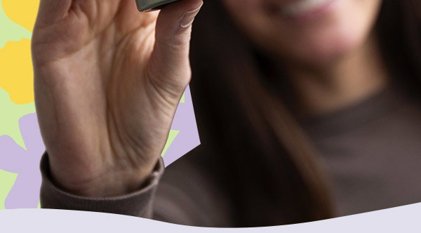 Woman smiling and holding up travel-size DOCTOR BABOR Microbiomic Stress Defense Cream