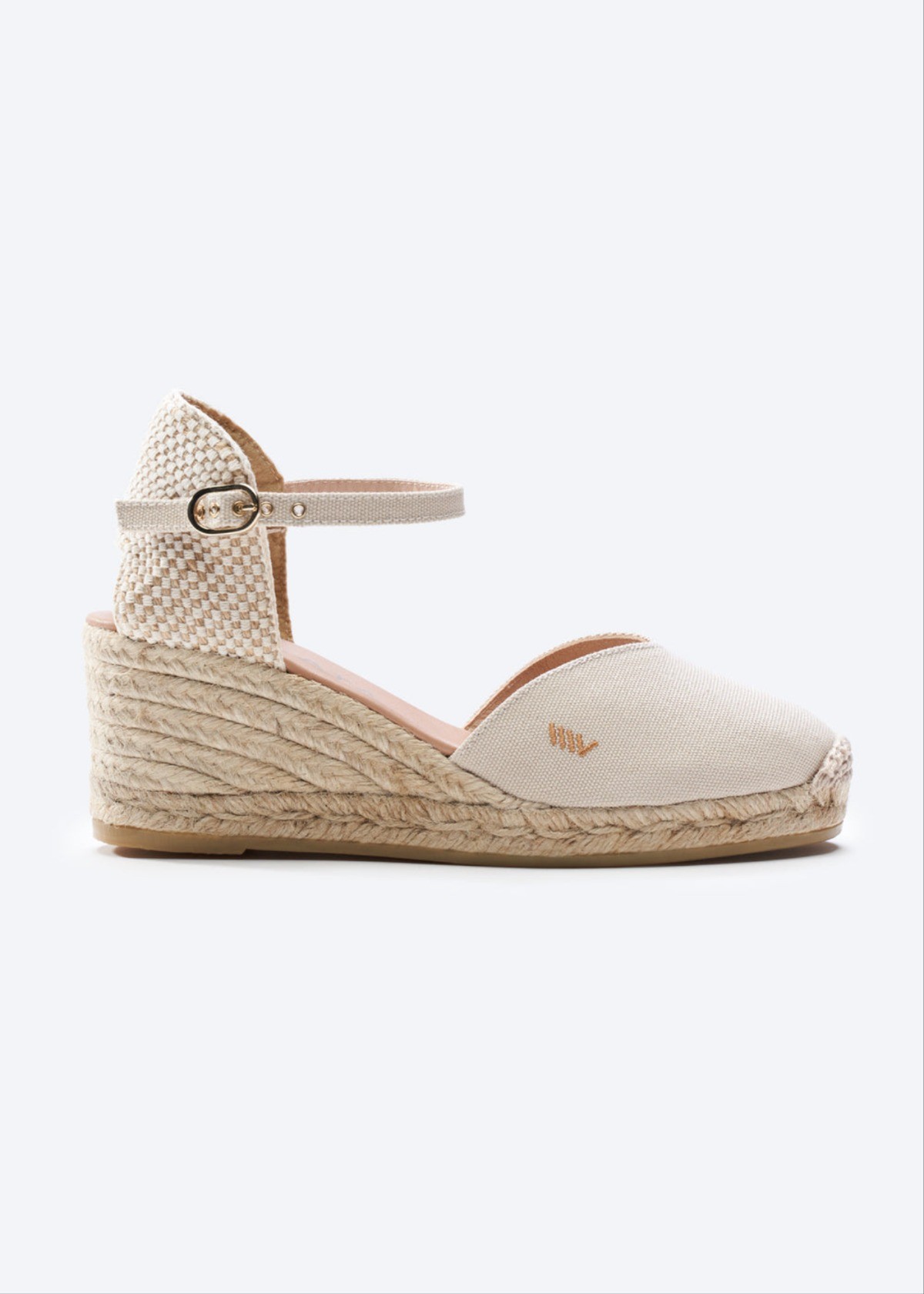 Cream canvas wedge espadrille sandal with ankle strap, closed toe, and braided jute heel for warm coastal days