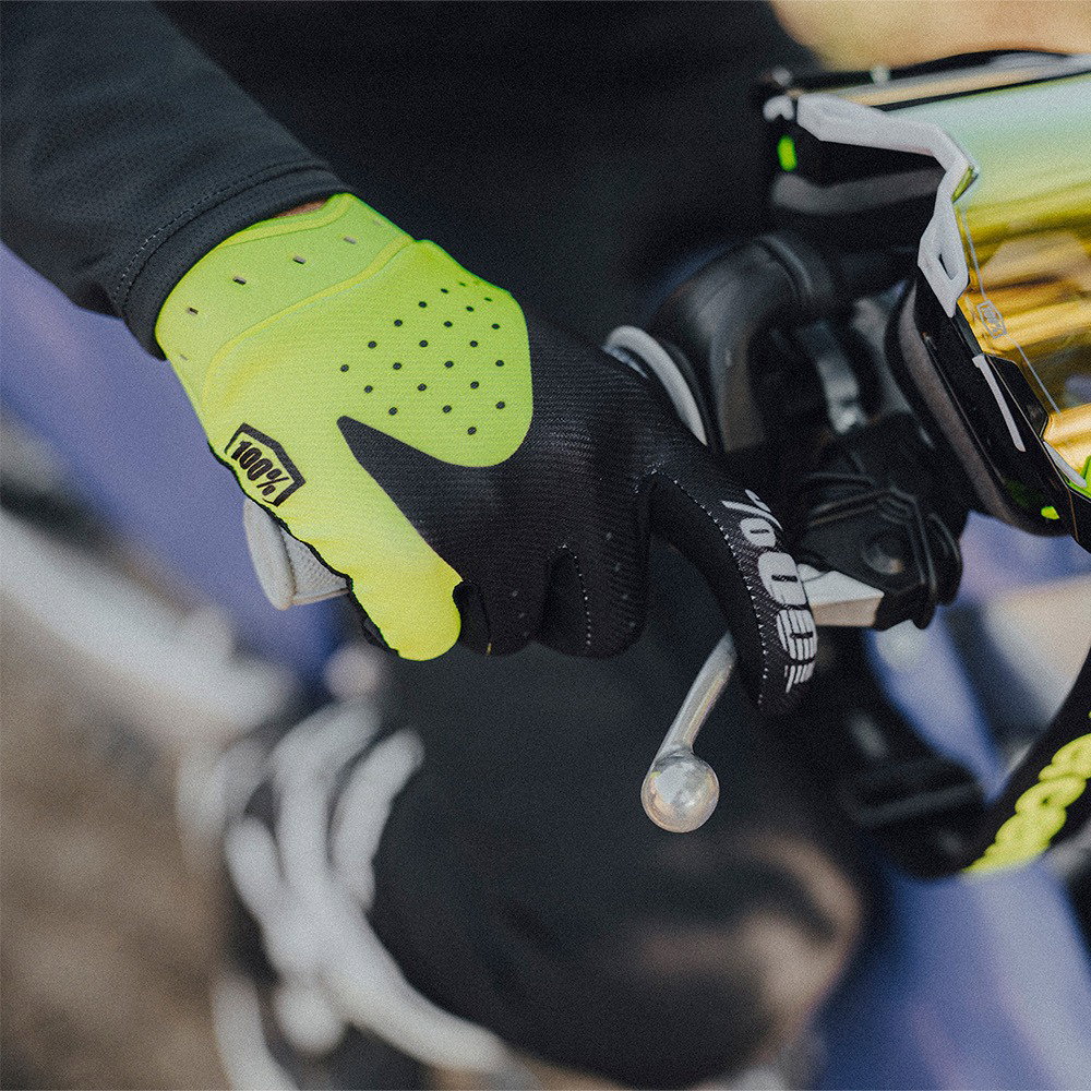 Rider wearing 100% iTrack gloves in Fluo Yellow during off-road riding