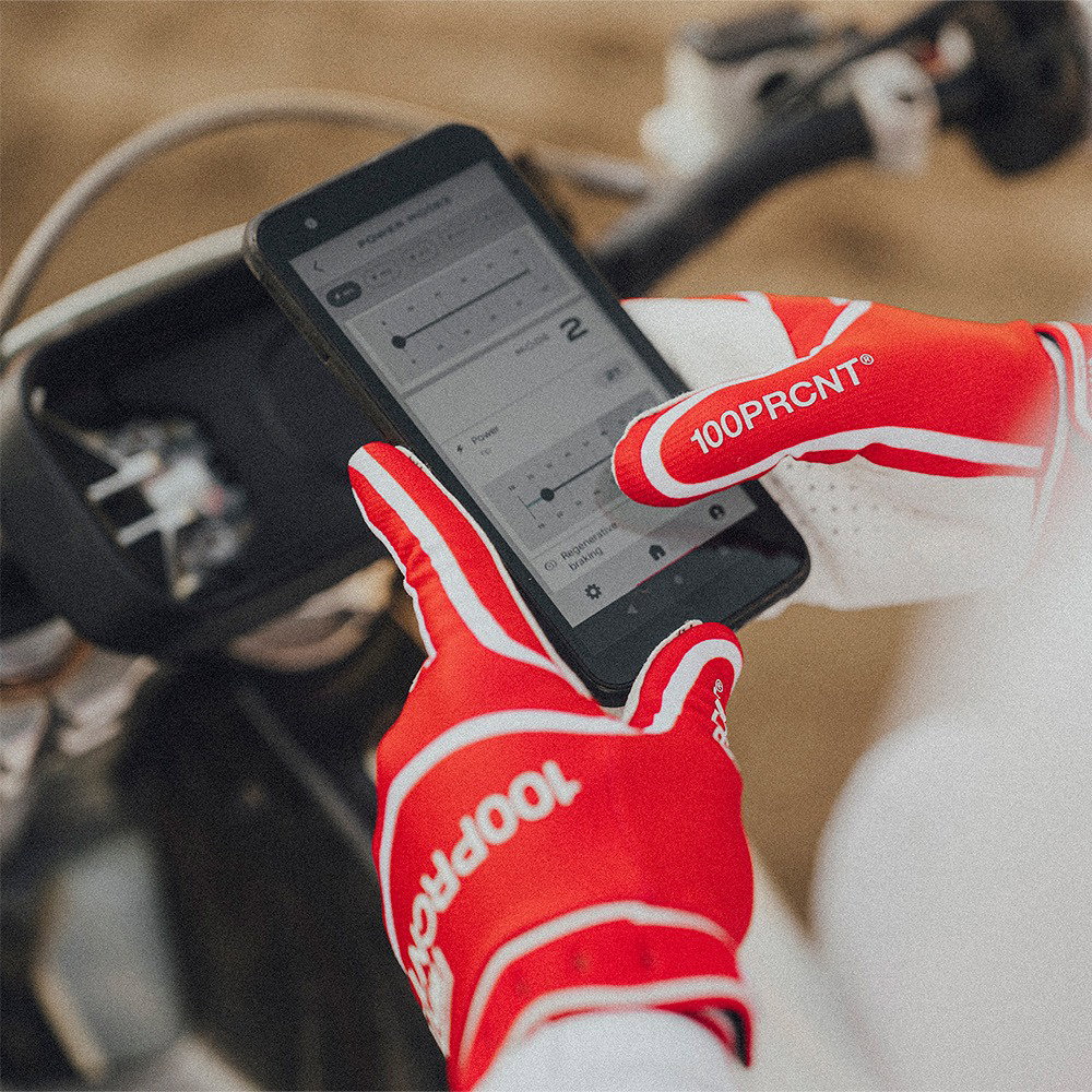 Motocross rider in action wearing 100% Ridefit gloves in Red and White