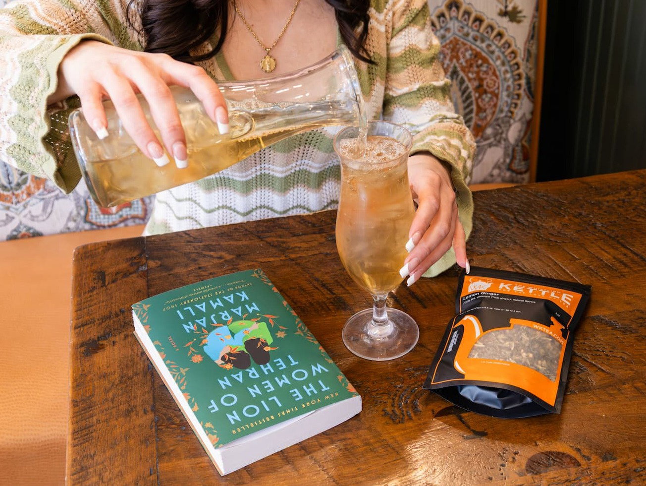 girl holding the list of supicious things book and cup of vanilla cream hot tea