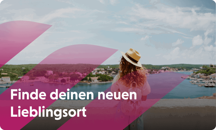 Frau mit Hut und Rucksack steht an einer Mauer und schaut auf einen Fluss. Jetzt neuen Lieblingsort finden.