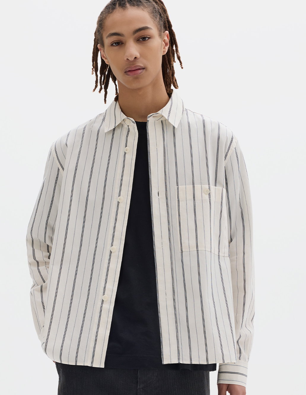 Striped shirt worn with a black t-shirt and dark trousers