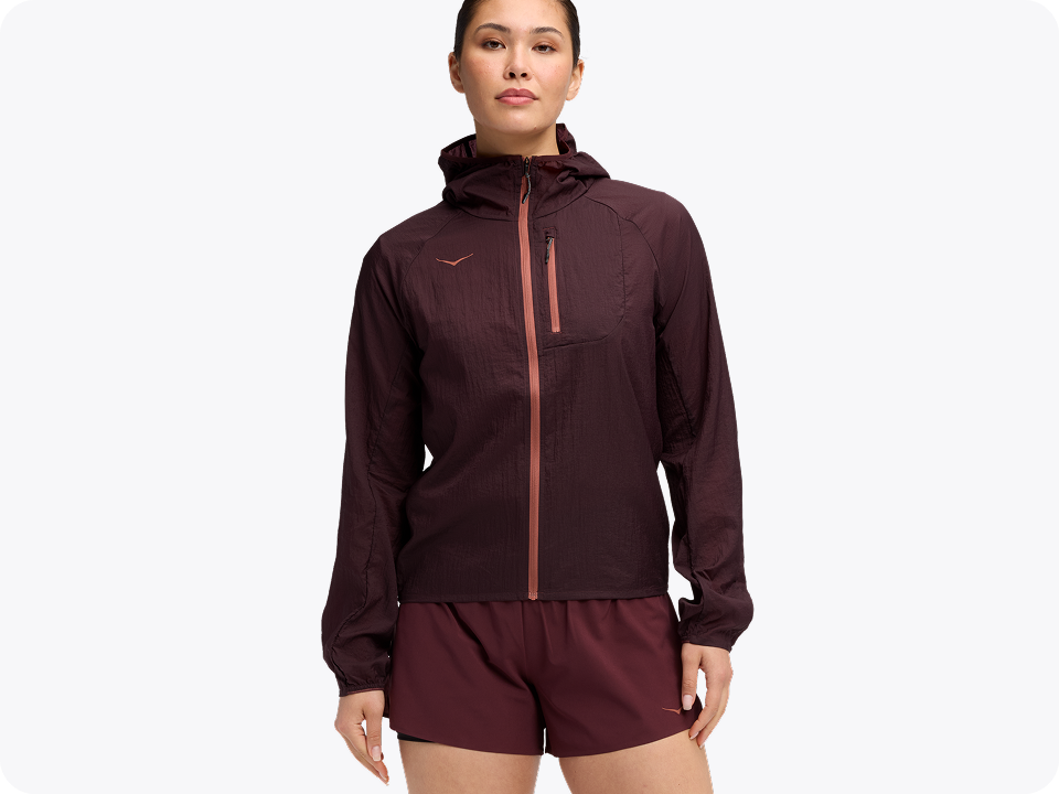 Woman wearing the skyflow jacket in Black Cherry and matching shorts, front view.