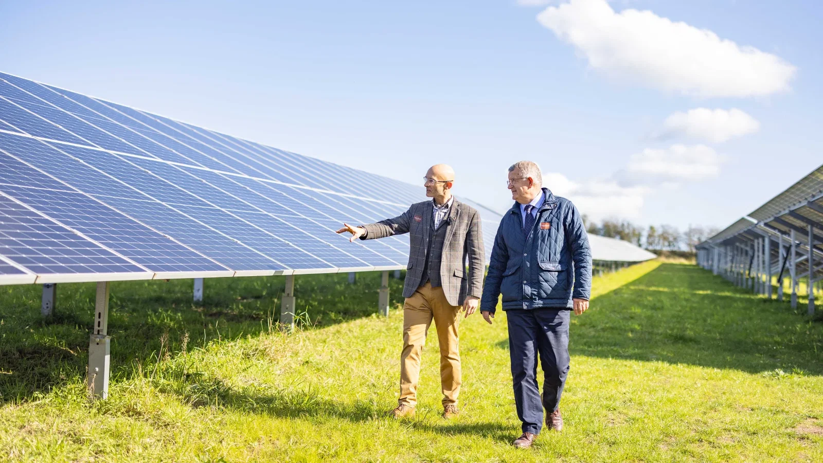 Bluestone's CEO & director of sustainability walking through Bluestone's solar field on a sunny day