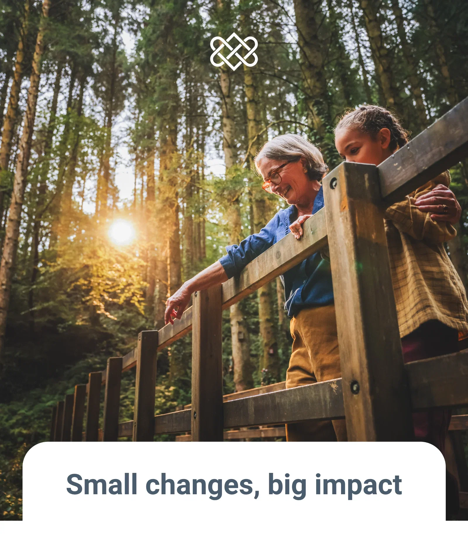 Grandmother and grandchild standing on a bridge in the forest at sunset smiling