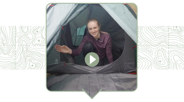 A still from a video, featuring a woman in the porch of a Highlander Respite 2 Tent. A green 