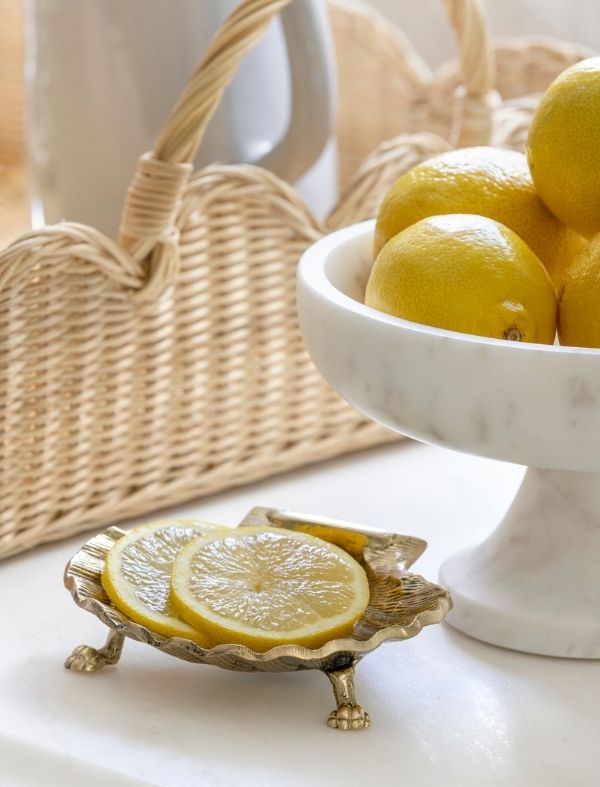 Coastal brass shell dish with lemon slices.