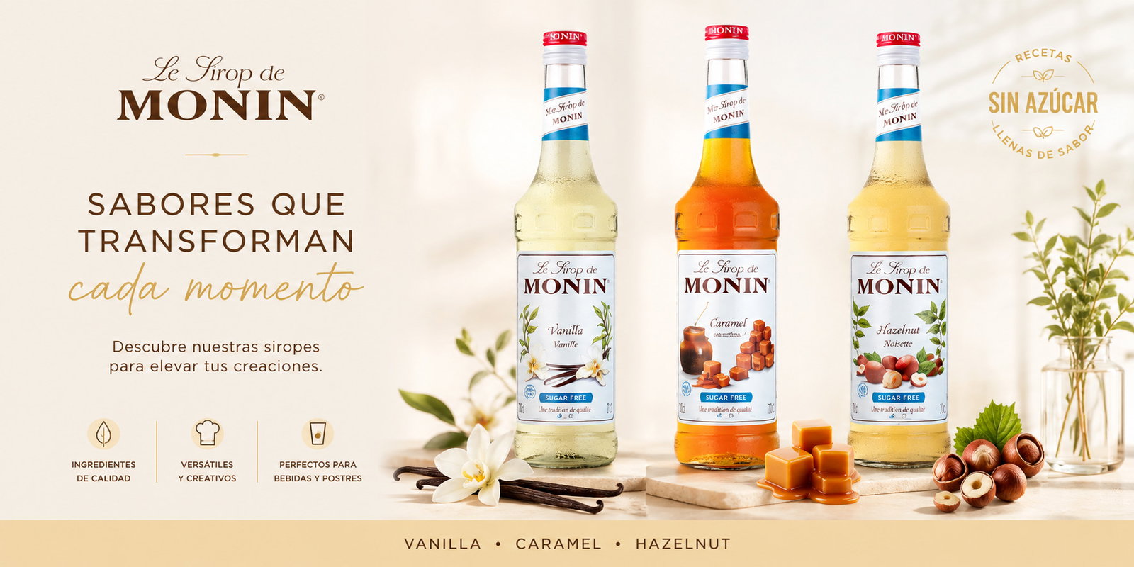 Three Monin sugar-free syrup bottles labelled Vanilla, Caramel and Hazelnut with vanilla pods, caramel cubes and hazelnuts