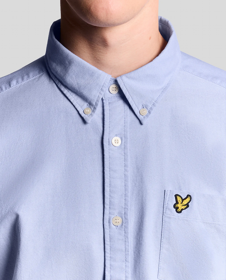 Man wears Cotton Button Down Oxford Shirt in Riviera