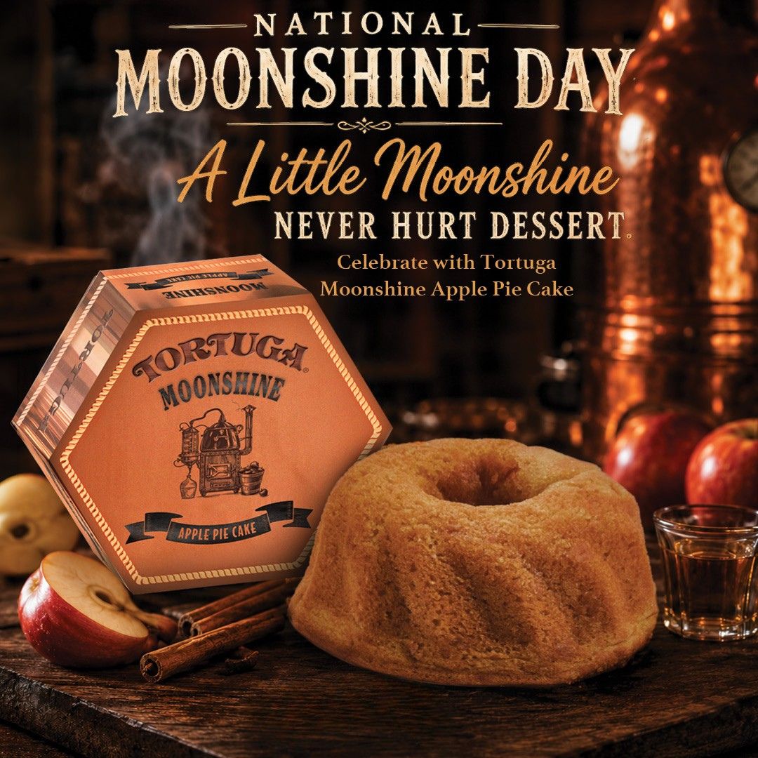 Tortuga Moonshine apple pie cake displayed on a wooden table with apples and cinnamon sticks.