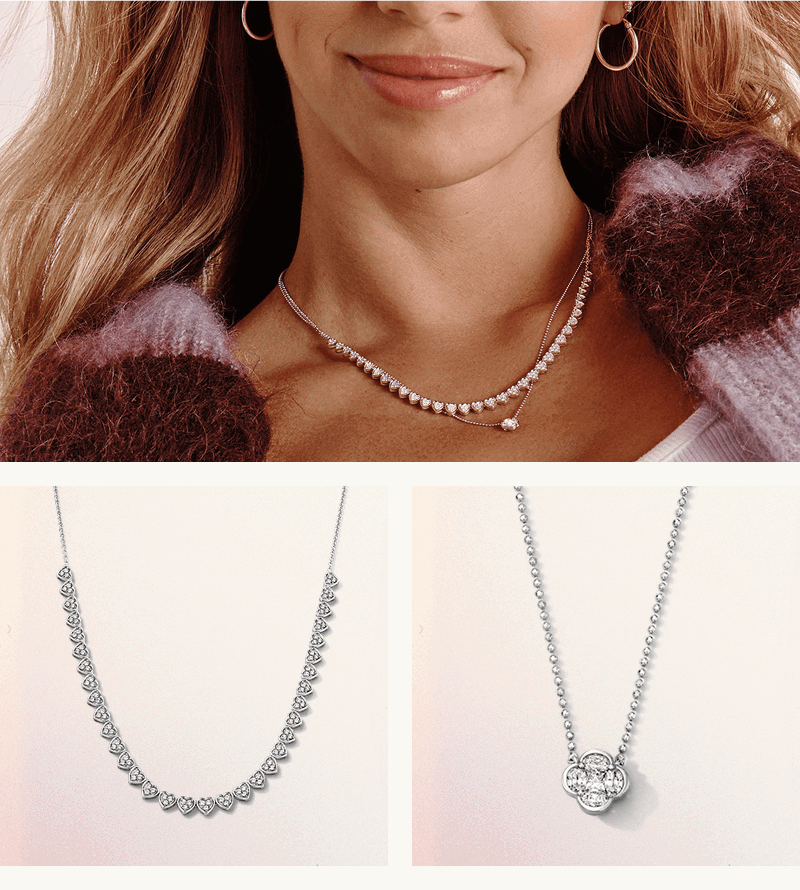Model smiling in heart-link tennis necklace & diamond clover-like pendant chain. Close-up of two products. 