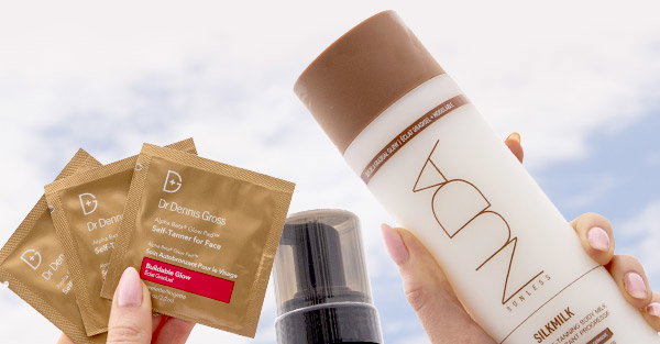 Hands holding self-tanning products in the air