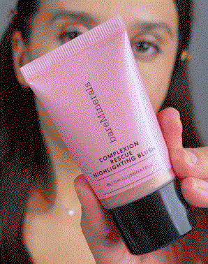 Model applying COMPLEXION RESCUE® HIGHLIGHTING BLUSH Highlighting blush