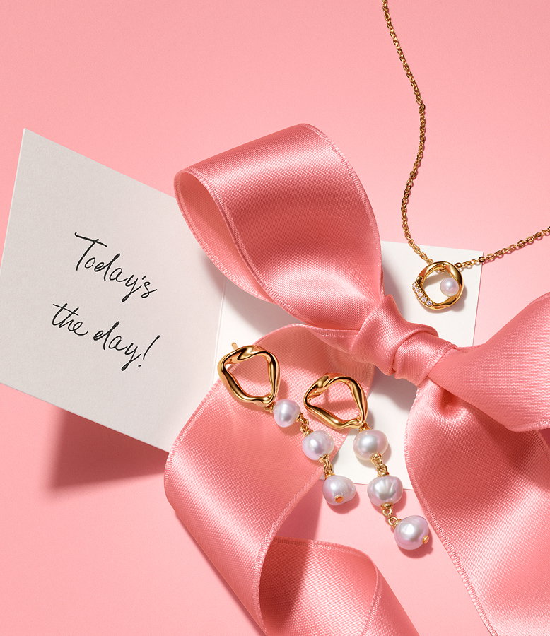 14k gold plated earrings with pearls and matching necklace sitting on a pink bow with a note that says 