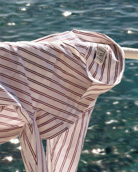 GIF of a striped shirt hanging on a rail.